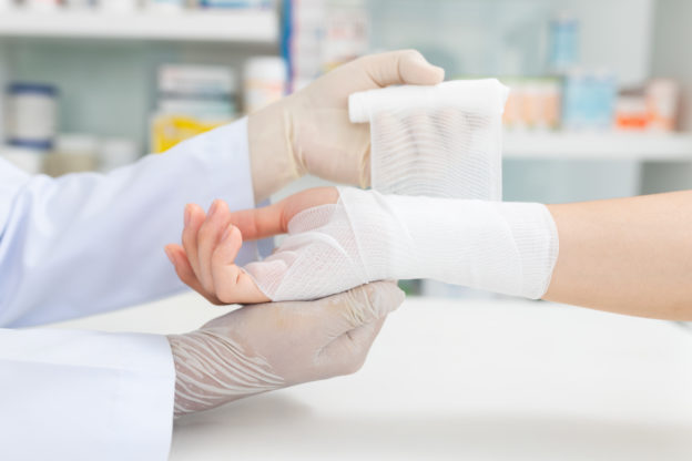 Close-up hand wear medical gloves Of Doctor Hand Tying Bandage